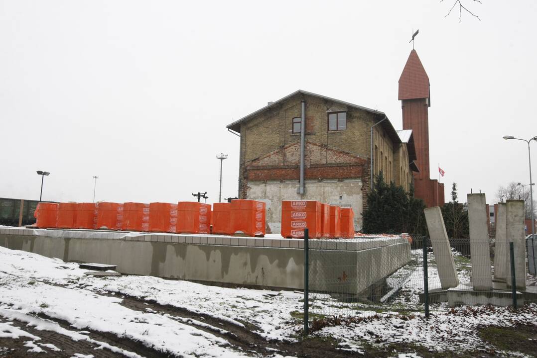 Klausimai: traukinių laukiantys keleiviai smalsauja, kas statoma šalia senosios geležinkelio stoties.