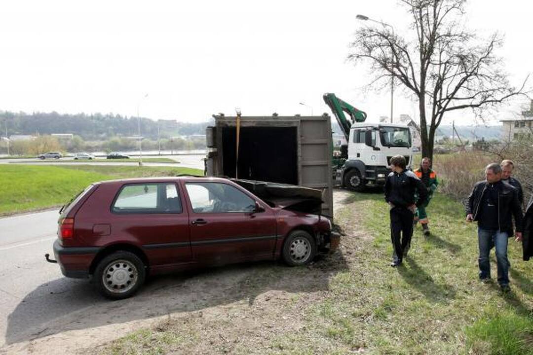 Konteineris užvirto ant pravažiuojančio automobilio