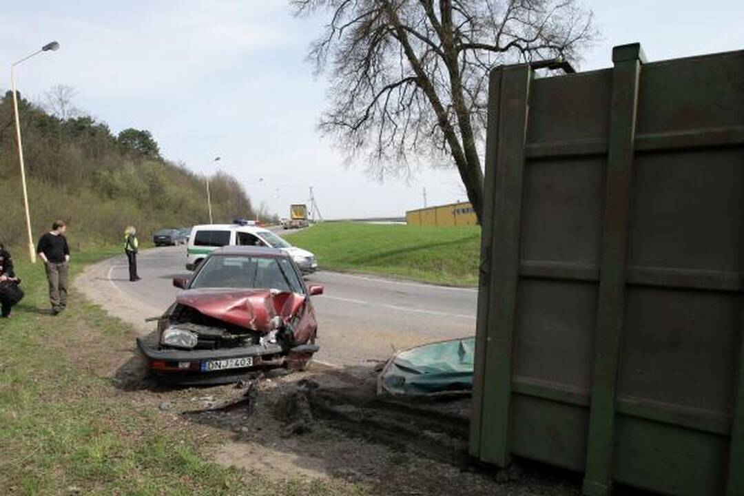 Konteineris užvirto ant pravažiuojančio automobilio
