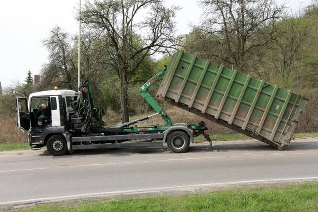 Konteineris užvirto ant pravažiuojančio automobilio