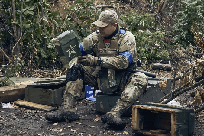 Skirtumai: Ukrainos karys tyrinėja maisto davinio, kuriuo maitinosi dabar jau išvaduotą Kupianską kontroliavę Rusijos kariai.